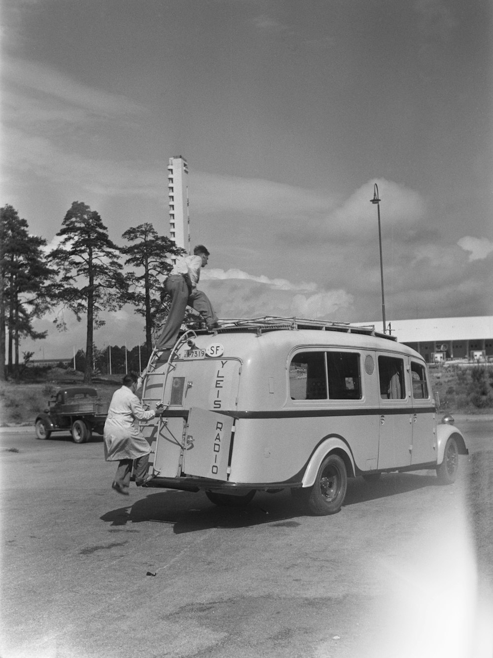 Photo: Yle Archives · Unsplash A uniformed crew unloading ladders from a work van