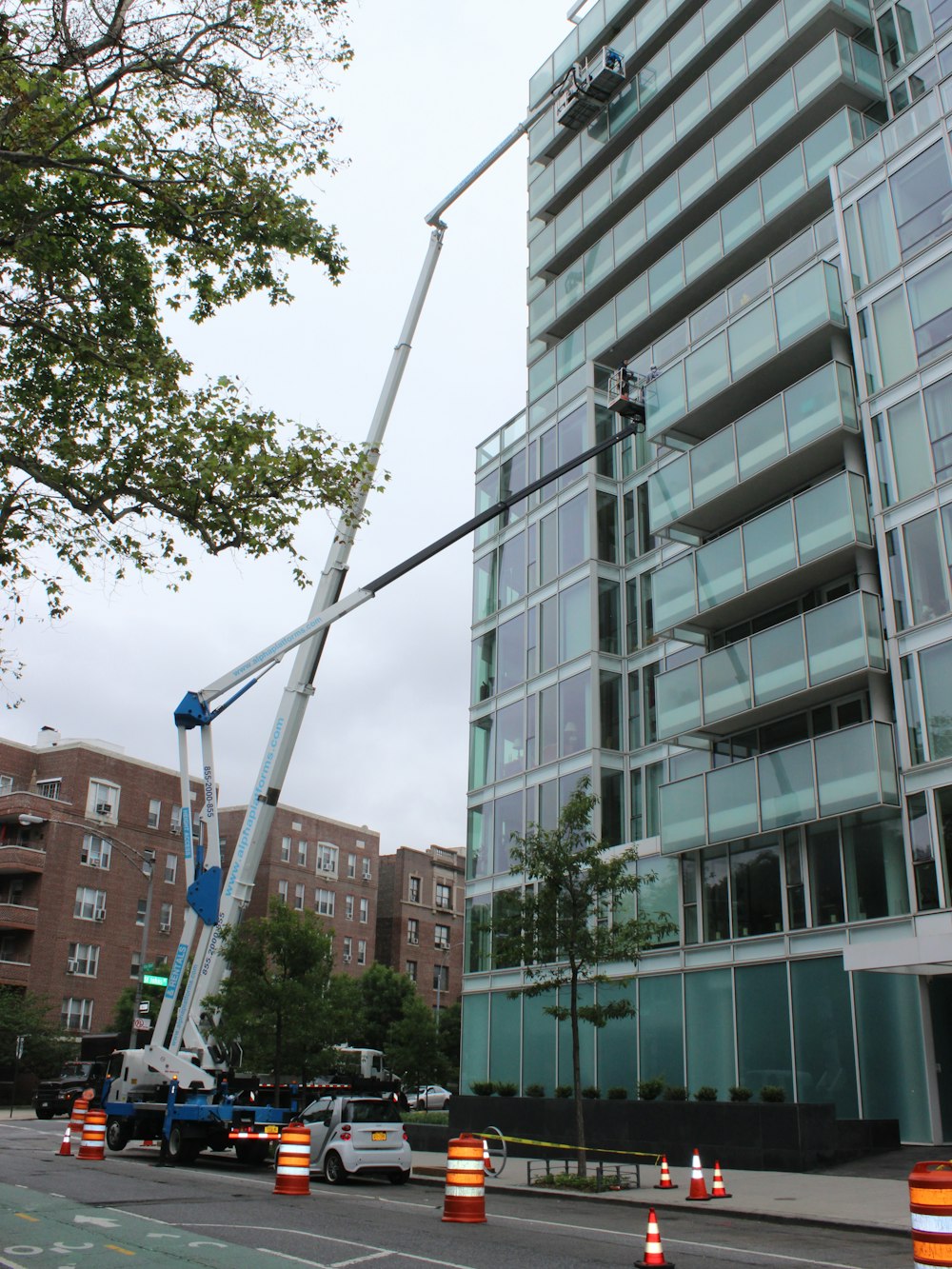 A window cleaner working from a lift high on a building facade