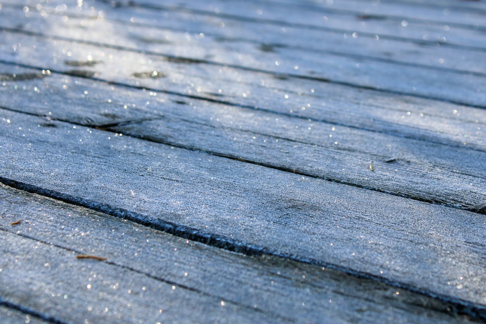 A clean stripe cut by a pressure washer across a weathered wooden deck